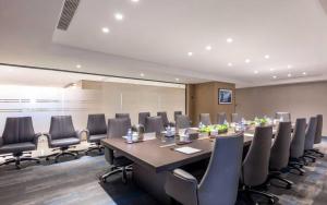 a conference room with a long table and chairs at JingLai Bushe Hotel Bund Nanjing West Road Shanghai in Shanghai
