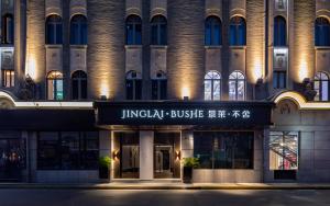 een gebouw met een bord aan de voorkant bij JingLai Bushe Hotel Shanghai in Shanghai