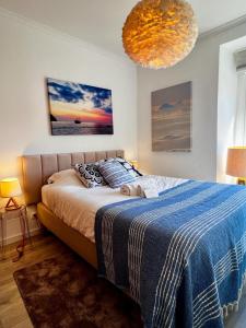 リスボンにあるCharm and Comfort Apartment 46 by Lisbonne Collectionのベッドルーム1室(青い毛布付きのベッド1台付)