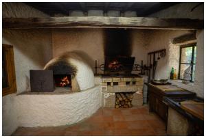 a kitchen with an oven with fire in it at Alojamento Estrela Cottage in Torrozelo