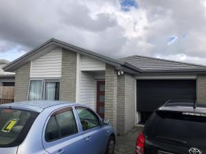 un coche azul estacionado frente a una casa en Stand alone house - Pukekohe, en Helvetia