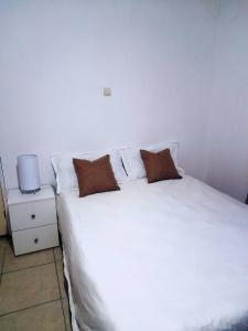 a white bed with two pillows on top of it at Katembe Beach Paradise in Maputo