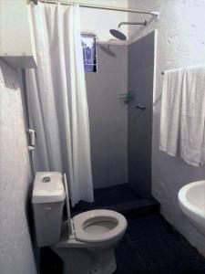 a bathroom with a toilet and a shower and a sink at Katembe Beach Paradise in Maputo