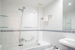 a white bathroom with a shower and a sink at Apartamentos GO Covaresa Parking Gratuito EXCEPTO ESTUDIOS in Valladolid +15 photos