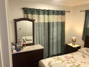 a bedroom with a mirror and a bed and a dresser at Stand alone house - Pukekohe in Helvetia