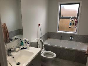 a bathroom with a sink and a toilet and a tub at Stand alone house - Pukekohe in Helvetia