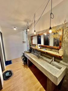 ein Badezimmer mit einem Steinwaschbecken und einem Spiegel in der Unterkunft Joyz House Da Lat in Da Lat