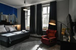 ein Schlafzimmer mit einem Bett und einem roten Stuhl in der Unterkunft Apartament Kopalnia przy Zamkowej w Wałbrzychu in Wałbrzych