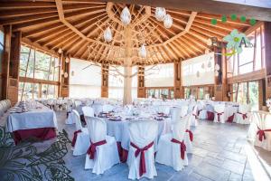 un salón de banquetes con mesas blancas y sillas blancas en Hotel Rural Peña Del Alba en Arroyomolinos de la Vera