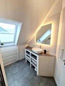 La salle de bains est pourvue d'un lavabo et d'un miroir. dans l'établissement Ferienwohnung Seedune, à Fehmarn