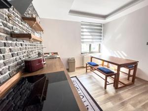 uma cozinha com uma mesa e uma parede de tijolos em 102- Intimate Home em Ancara