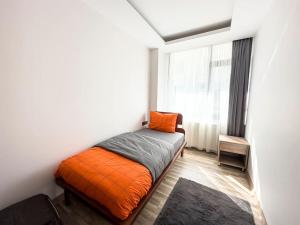 a small bedroom with an orange bed and a window at 102- Intimate Home in Ankara