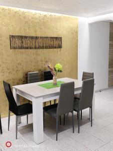 Golden Ambient Apartment في Chirivella: طاولة طعام مع كراسي وطاولة بيضاء
