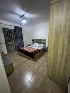 a bedroom with a bed and a wooden floor at CAI-Transit Sleep and Free 2-Ways-taxi in Cairo