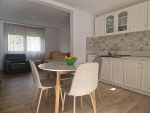 a kitchen and dining room with a table and chairs at Sofija, Guests House in Ključ