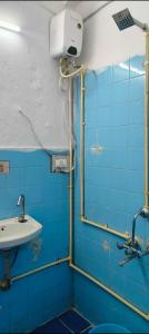 y baño de azulejos azules con lavabo y ducha. en Royal great Friendly Rooms Banjara hills 7, en Hyderabad