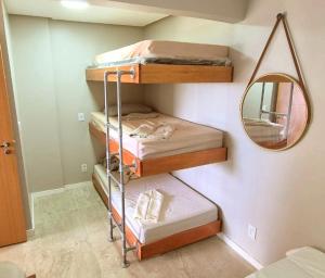 Zimmer mit 4 Etagenbetten und einem Spiegel in der Unterkunft Salt Beach Residence Inn in Salinópolis