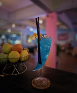 a blue drink sitting on a table next to a bowl of fruit at Tiki Tribe Bar & Hostel in Ko Tao