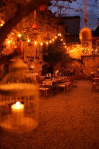 um restaurante com luzes, mesas e velas em Macaron Konagi em Ayvalık