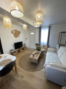 a living room with a couch and a table at Bmco cottage in Estrées-Saint-Denis