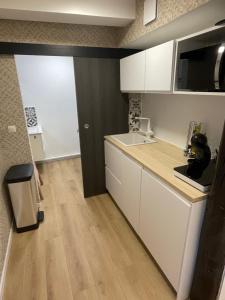 une cuisine avec des armoires blanches et un comptoir dans l'établissement Bmco cottage, à Estrées-Saint-Denis 1 autre photo