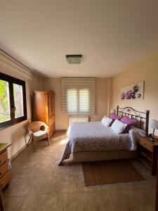 um quarto com uma cama, uma cadeira e uma janela em Harizpe em Ondárroa