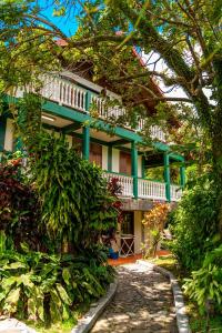 a green and white building with a balcony at Roxy's Mountain Lodge in Roseau