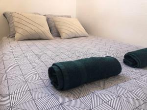 a bed with a green rolled up towel on it at Le Buc - Gare Versailles Chantiers - Netflix in Versailles