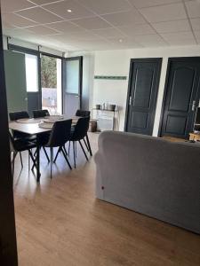 een kamer met een tafel en stoelen en een bank bij Appartement 3 pièces in Saint-Paul-et-Valmalle