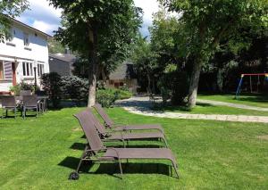 een rij parkbanken in het gras bij Family home with pool and large garden in Becerril de la Sierra