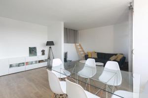 een woonkamer met een glazen tafel en witte stoelen bij Joli Duplex rénové à neuf de 72m² in Fresnes