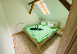 ein Schlafzimmer mit einem grünen Bett im Dachgeschoss in der Unterkunft Ochelschmiede in Rathmannsdorf