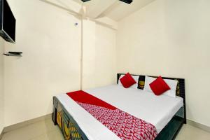 a bedroom with a bed with red pillows at OYO Flagship Residence Inn Guest House in Patna