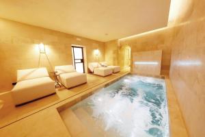 a swimming pool in a room with a couch and chairs at Casa Nostra Boutique Hotel & Spa in Palermo