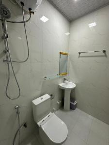 een witte badkamer met een toilet en een wastafel bij The Happiness Sun Suites in Fodhdhoo