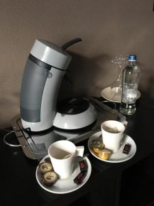 a coffee maker and two cups of coffee on a table at B&B De Kaai in Nieuwpoort