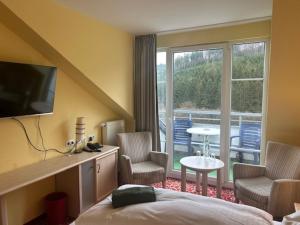 a hotel room with a bed and a balcony at Waldhaus am See in Willingen