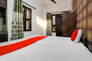 a bedroom with a white bed with red pillows at OYO Flagship Corporate House in Gurgaon