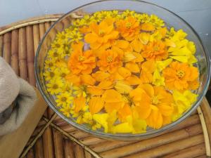 a bowl filled with yellow flowers on top of a basket at Amanda อามันดา in Ban Pak Ba Ra