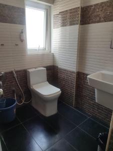 a bathroom with a white toilet and a sink at PRIME SUITES in Bangalore