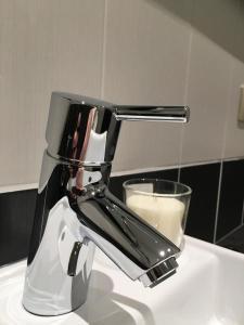 ein Gemisch auf einem Waschbecken mit einem Glas Milch in der Unterkunft B&B De Kaai in Nieuwpoort