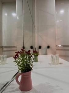 a vase with flowers on a table in a bathroom at GREEN DOOR HOTEL in Tbilisi City