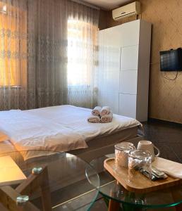 a bedroom with a bed and a table with towels at GREEN DOOR HOTEL in Tbilisi City