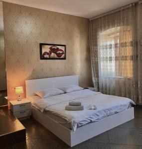 a bedroom with a white bed and a window at GREEN DOOR HOTEL in Tbilisi City