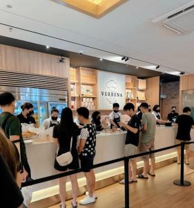 a group of people standing around a counter in a restaurant at Sky Tree Studio Apartment at Bukit Indah, Johor in Johor Bahru