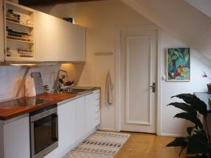 a kitchen with white cabinets and a sink and a door at Spacious Penthouse close to center in Stockholm