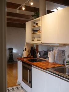 a kitchen with white cabinets and a sink and a stove at Spacious Penthouse close to center in Stockholm