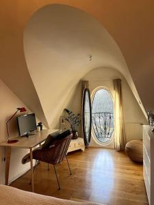 an attic room with a desk and a window at Spacious Penthouse close to center in Stockholm