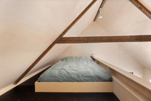 een bed op zolder van een loft bij Hello Zeeland - Tiny Houses Groede in Groede