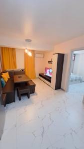 a living room with a table and a tv at Аэропорт Апартаменты 24&24 Parking in Chişinău